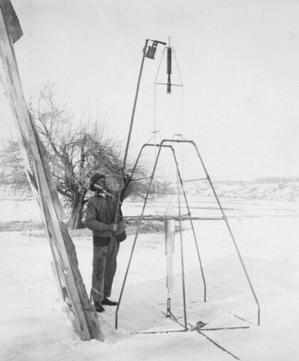 Fotografie asistenta Roberta Goddarda Henryho Sachse, jak zapaluje raketu 16. března 1926. Zdroj: Clark University