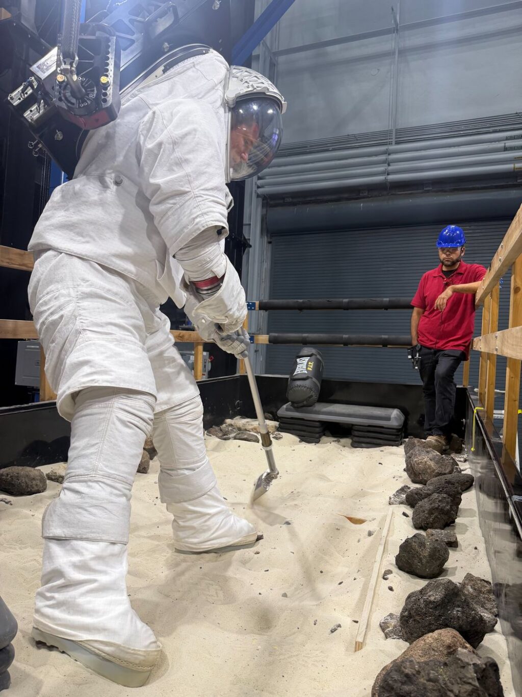 Jeremy Hansen v lunárním skafandru nacvičuje práci s nástroji nedlouho poté, co absolvoval misi Artemis II