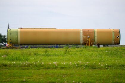 Přeprava centrálního stupně pro Artemis III z MAF k člunu Pegasus, 20. dubna 2026. Na vodíkovou nádrž je připojena pouze část vnějšího potrubí pro kapalný kyslík, na spojích mezi díly chybí pěnová izolace, motorová sekce je pro přepravu nahrazena transportním adaptérem (zelený díl vlevo).