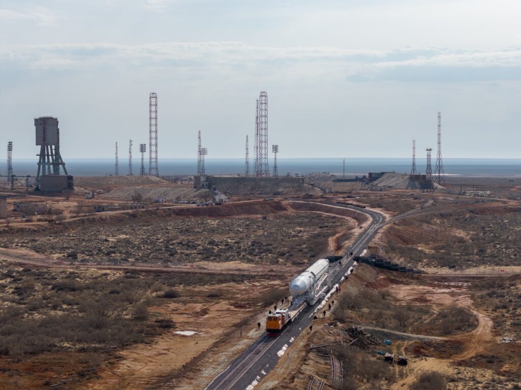 Na tomto snímku je v pozadí již vidět i samotná rampa, kam raketa míří. Foto: Roskosmos. 