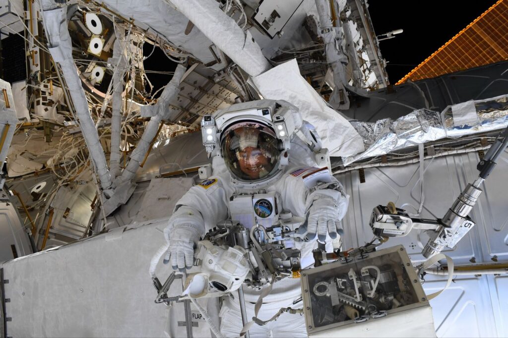 Christina Koch během kosmické vycházky, během které bylo úkolem vyměnit vadný kloub robotického ramene Canadarm-2