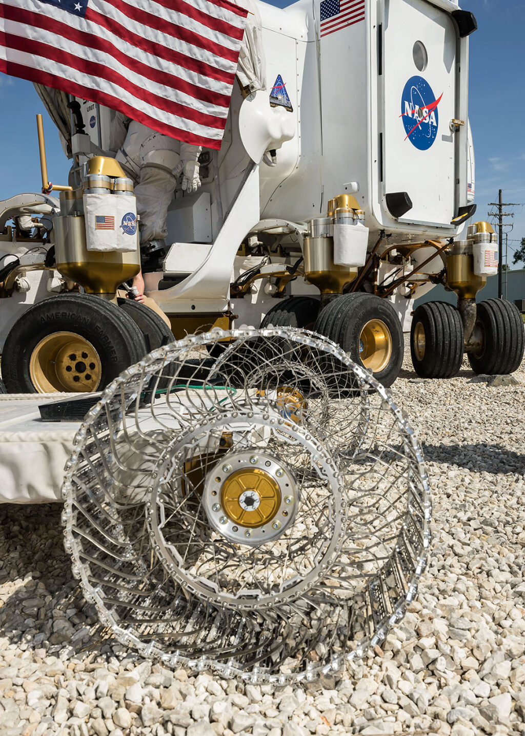 Prototyp lunárního kola HTR Variable Flex Lunar Wheel vedle Space Exploration Vehicle agentury NASA na Rock Yard Johnsonova střediska.